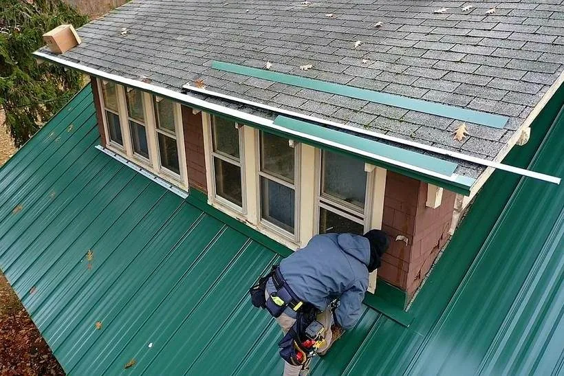 Roofing crew installing metal roof panels on a client project